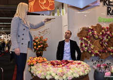 Pini Cohen van Decofresh kijkt naar een mooie vrouw die een foto maakt van zijn bloemenkunstwerk. 