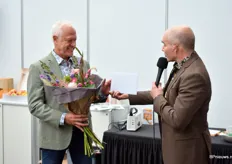 Peter Derksen (links), voormalig directeur van Stichting Boomfeestdat, krijgt een bos bloemen en presentje overhandigd door David Bömer (rechts), voorzitter dan GrootGroen Plus, vanwege zijn aftreden als directeur.